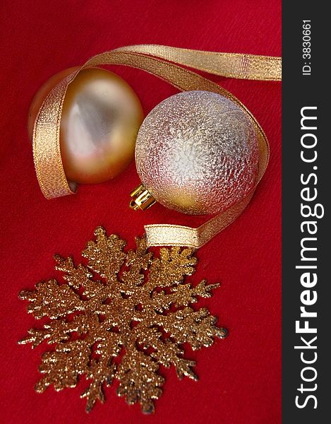 Golden christmas ornaments with a tape and a snowflake On a red background