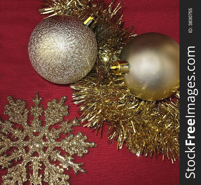 Golden christmas ornaments with tinsel and snowflake 
On  red background