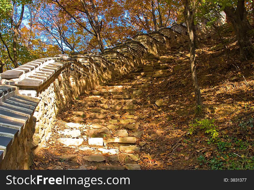 Asian ancient wall and step stones at fall forest