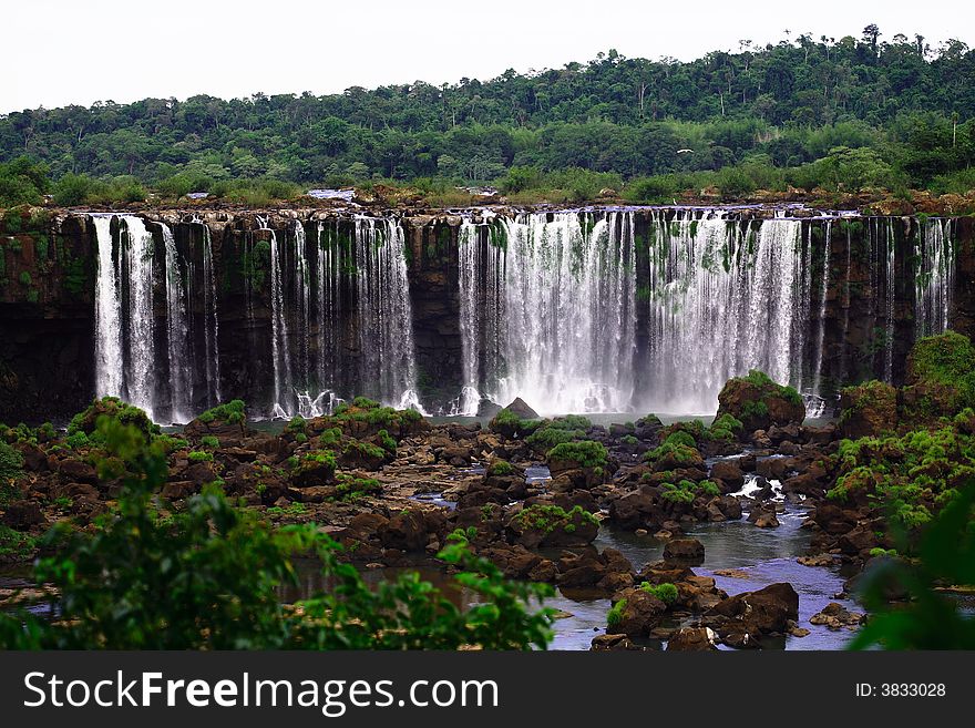 The Iguassu (or Iguazu) Falls is one of the largest masses of fresh water on the planet and divides, in South America, Brazil, Paraguay and Argentina. The waterfall system consists of 275 falls along 2.7 kilometres (1.67 miles) of the Iguazu River. Some of the individual falls are up to 82 metres (269 feet) in height, though the majority are about 64 metres (210 feet). The Iguassu (or Iguazu) Falls is one of the largest masses of fresh water on the planet and divides, in South America, Brazil, Paraguay and Argentina. The waterfall system consists of 275 falls along 2.7 kilometres (1.67 miles) of the Iguazu River. Some of the individual falls are up to 82 metres (269 feet) in height, though the majority are about 64 metres (210 feet).