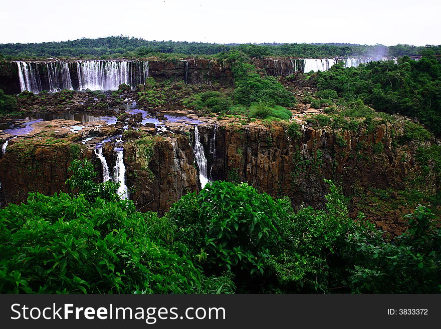 The Iguassu (or Iguazu) Falls is one of the largest masses of fresh water on the planet and divides, in South America, Brazil, Paraguay and Argentina. The waterfall system consists of 275 falls along 2.7 kilometres (1.67 miles) of the Iguazu River. Some of the individual falls are up to 82 metres (269 feet) in height, though the majority are about 64 metres (210 feet). The Iguassu (or Iguazu) Falls is one of the largest masses of fresh water on the planet and divides, in South America, Brazil, Paraguay and Argentina. The waterfall system consists of 275 falls along 2.7 kilometres (1.67 miles) of the Iguazu River. Some of the individual falls are up to 82 metres (269 feet) in height, though the majority are about 64 metres (210 feet).