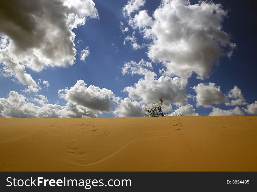 Deserted landscape against the blue sky with expressive clouds. Deserted landscape against the blue sky with expressive clouds