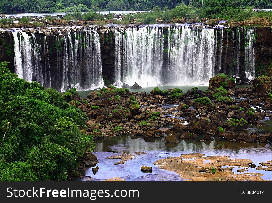 The Iguassu (or Iguazu) Falls is one of the largest masses of fresh water on the planet and divides, in South America, Brazil, Paraguay and Argentina. The waterfall system consists of 275 falls along 2.7 kilometres (1.67 miles) of the Iguazu River. Some of the individual falls are up to 82 metres (269 feet) in height, though the majority are about 64 metres (210 feet). The Iguassu (or Iguazu) Falls is one of the largest masses of fresh water on the planet and divides, in South America, Brazil, Paraguay and Argentina. The waterfall system consists of 275 falls along 2.7 kilometres (1.67 miles) of the Iguazu River. Some of the individual falls are up to 82 metres (269 feet) in height, though the majority are about 64 metres (210 feet).