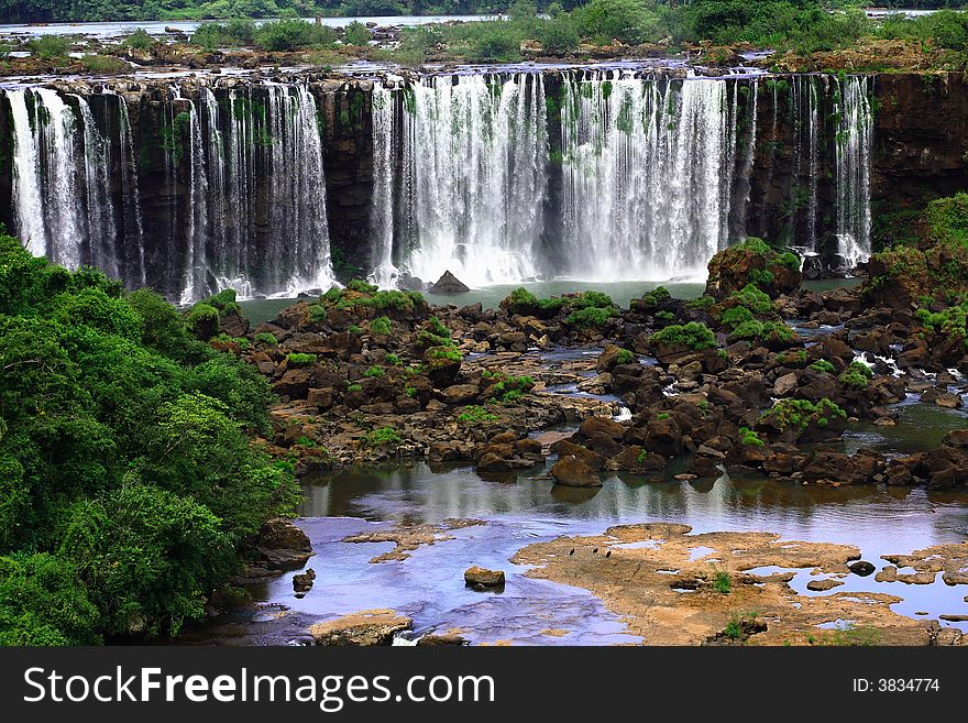 The Iguassu (or Iguazu) Falls is one of the largest masses of fresh water on the planet and divides, in South America, Brazil, Paraguay and Argentina. The waterfall system consists of 275 falls along 2.7 kilometres (1.67 miles) of the Iguazu River. Some of the individual falls are up to 82 metres (269 feet) in height, though the majority are about 64 metres (210 feet). The Iguassu (or Iguazu) Falls is one of the largest masses of fresh water on the planet and divides, in South America, Brazil, Paraguay and Argentina. The waterfall system consists of 275 falls along 2.7 kilometres (1.67 miles) of the Iguazu River. Some of the individual falls are up to 82 metres (269 feet) in height, though the majority are about 64 metres (210 feet).