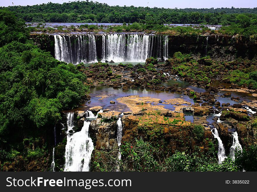 The Iguassu (or Iguazu) Falls is one of the largest masses of fresh water on the planet and divides, in South America, Brazil, Paraguay and Argentina. The waterfall system consists of 275 falls along 2.7 kilometres (1.67 miles) of the Iguazu River. Some of the individual falls are up to 82 metres (269 feet) in height, though the majority are about 64 metres (210 feet). The Iguassu (or Iguazu) Falls is one of the largest masses of fresh water on the planet and divides, in South America, Brazil, Paraguay and Argentina. The waterfall system consists of 275 falls along 2.7 kilometres (1.67 miles) of the Iguazu River. Some of the individual falls are up to 82 metres (269 feet) in height, though the majority are about 64 metres (210 feet).