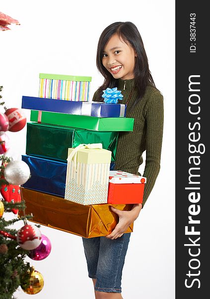 A cheerful girl holding a bunch of christmas gift