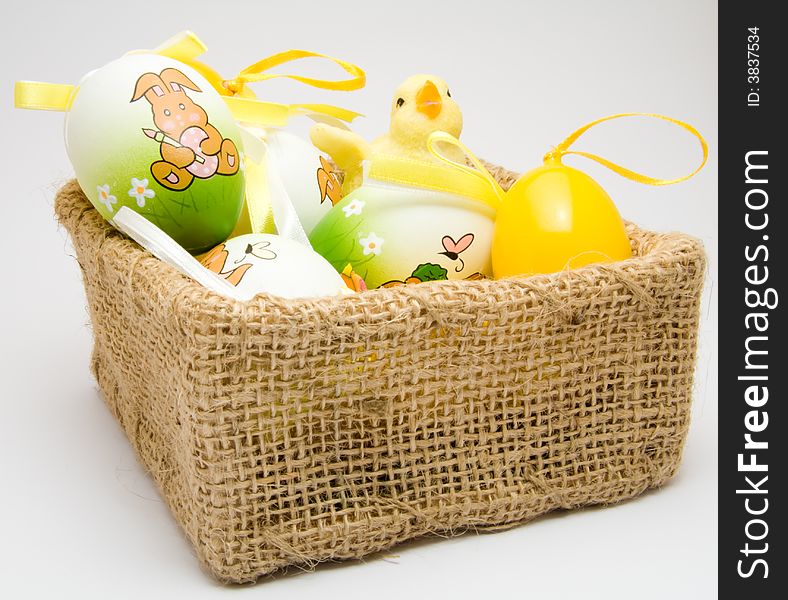 Easter eggs and chick in a cloth basket