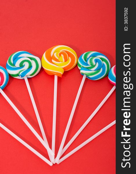 Twirl lollipop candies over a red background