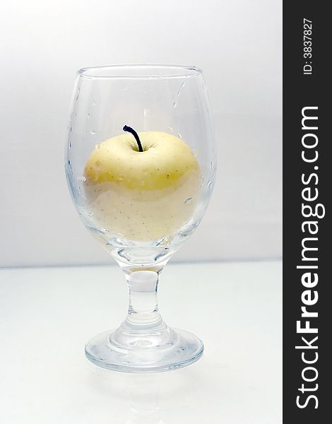Yellow apple in a tall wet glass. Yellow apple in a tall wet glass