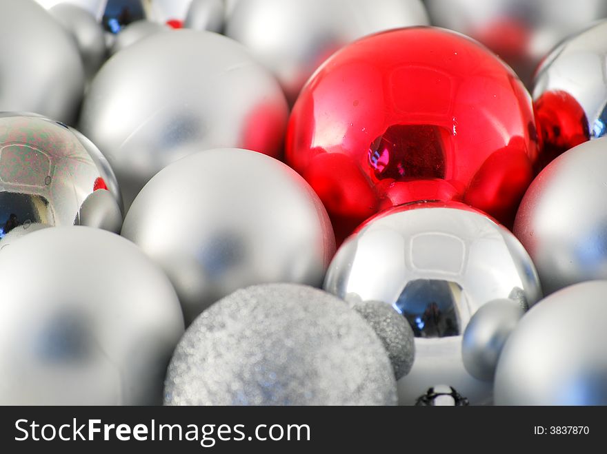 Random silver and one red christmas balls close together. Focus on the red bal. Random silver and one red christmas balls close together. Focus on the red bal.