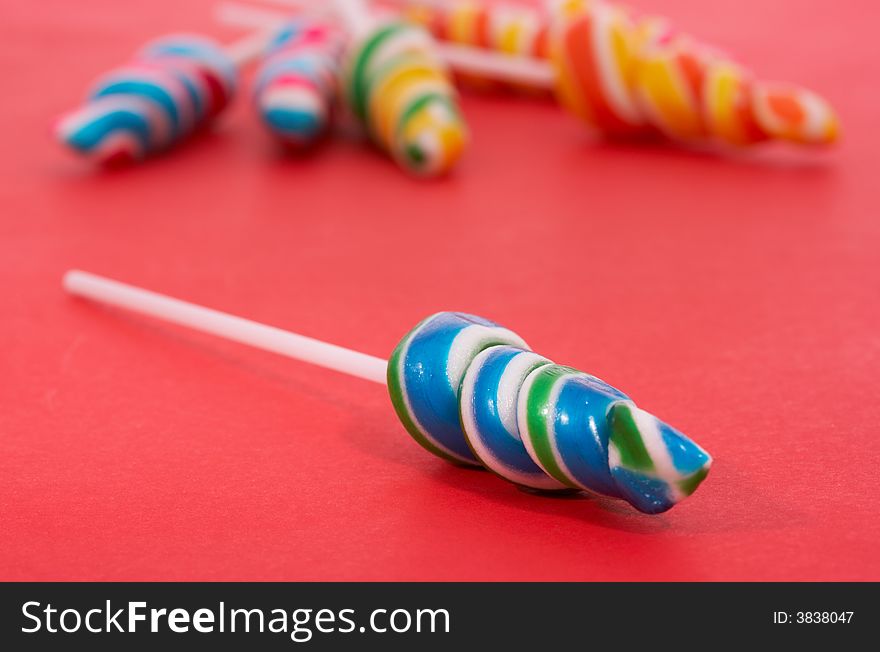 Twirl lollipop candies over a red background