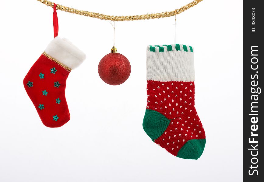 Christmas stockings and a bauble hanging over a white background