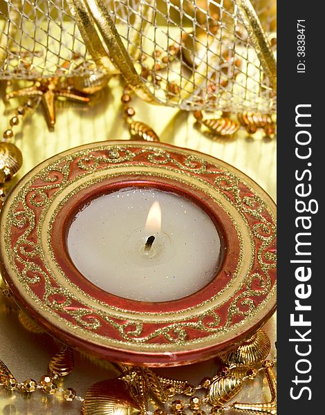 Red candle on golden background