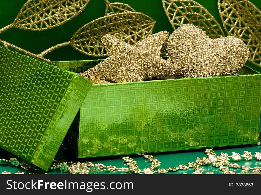 Green gift box and golden celebration leaves