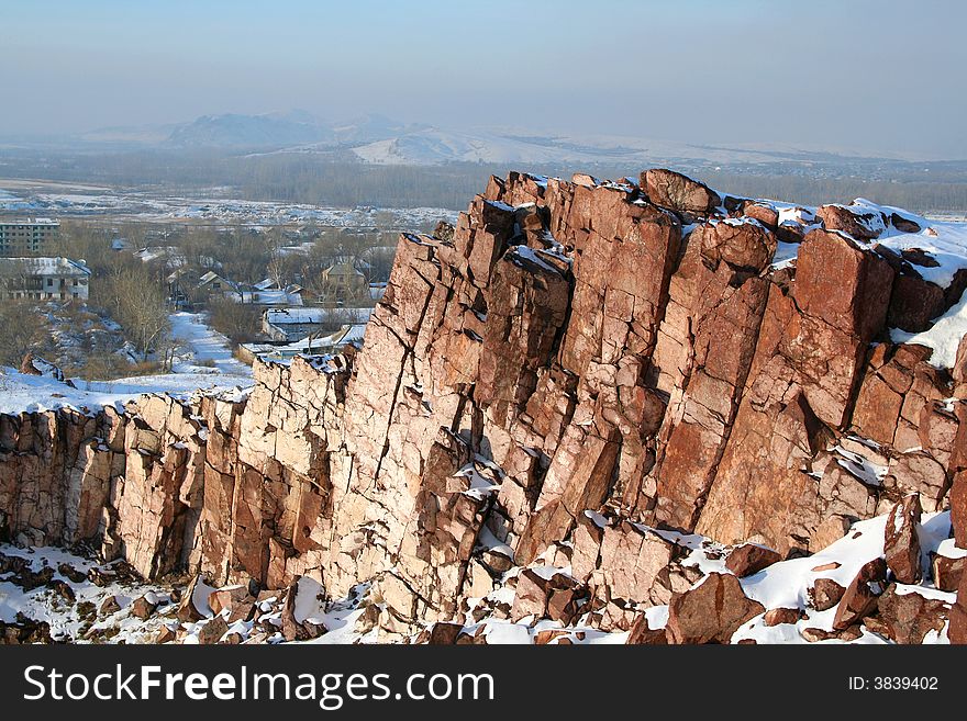 Steep rock in the winter. Village