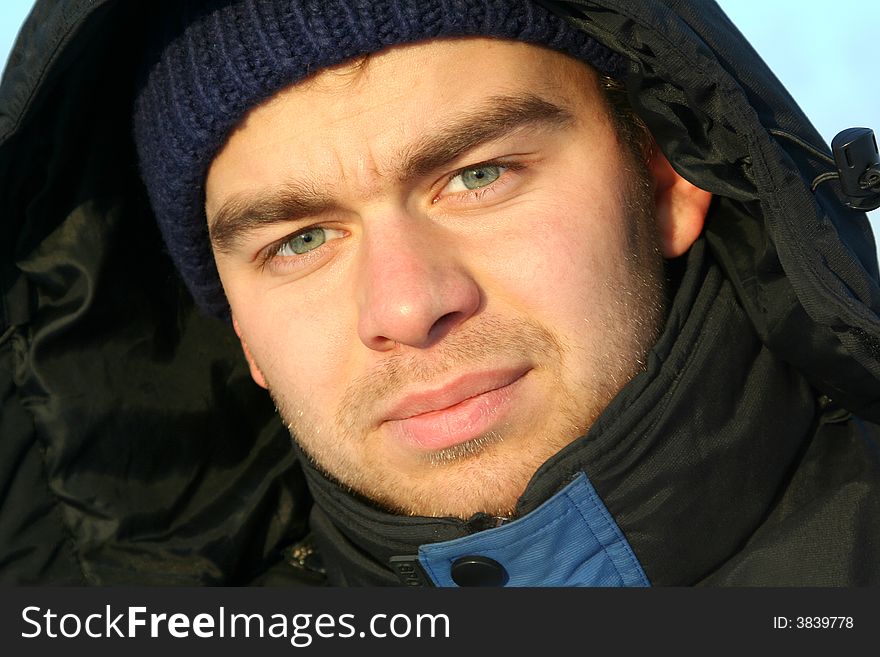 Outdoor portrait of attractive guy in hood. Outdoor portrait of attractive guy in hood