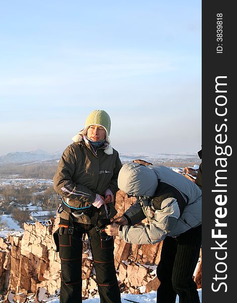 Girl rock-climber on rock in winter