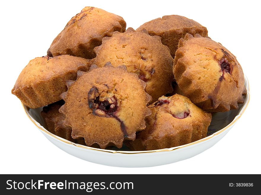 Tasty small baked cakes filled with cherry and raisins in white round bowl isolated on white. Tasty small baked cakes filled with cherry and raisins in white round bowl isolated on white