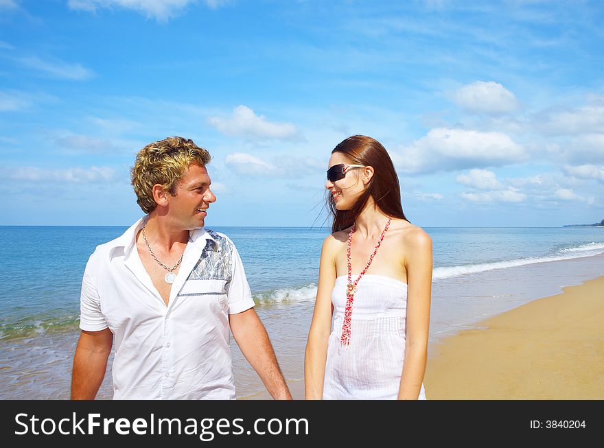 A portrait of attractive couple having walk along the shore. A portrait of attractive couple having walk along the shore