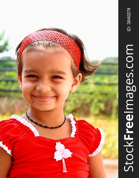 A small girl with bright face and beautiful red frock. A small girl with bright face and beautiful red frock.