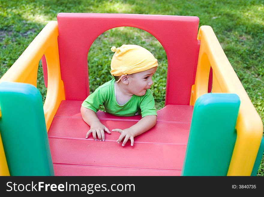 A cute little caucasian boy with happy smiling facial expression playing on a jungle gym in the backyard outdoors. A cute little caucasian boy with happy smiling facial expression playing on a jungle gym in the backyard outdoors