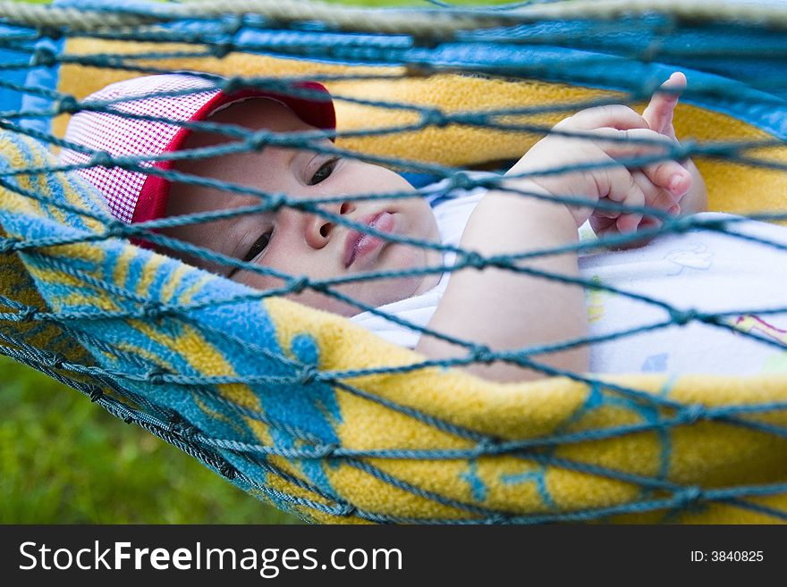 A view of a baby boy as he lies resting in a hammock. A view of a baby boy as he lies resting in a hammock.