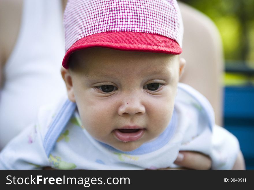 A closeup of an adorable baby boy, wearing a red and white checkered cap. A closeup of an adorable baby boy, wearing a red and white checkered cap.