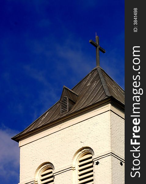 Lone church against perfect blue sky with cross