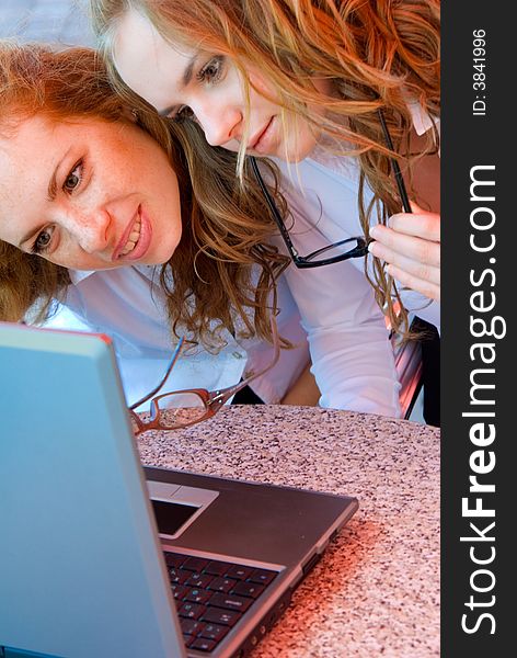 Two young beautiful girls working on laptop. Two young beautiful girls working on laptop