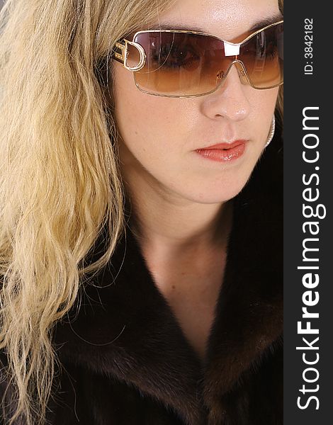 Shot of a beautiful blonde in mink fur and glasses