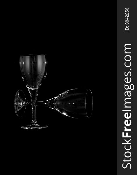 Thin wine glasses againt a black background, floating, straight up and sideways. Thin wine glasses againt a black background, floating, straight up and sideways