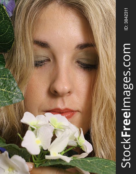 Shot of a woman headshot smelling flower