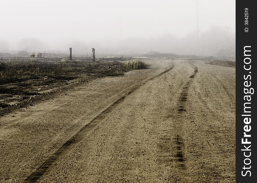 Tire tracks in dirt heading of into the distance on a foggy day. Tire tracks in dirt heading of into the distance on a foggy day.