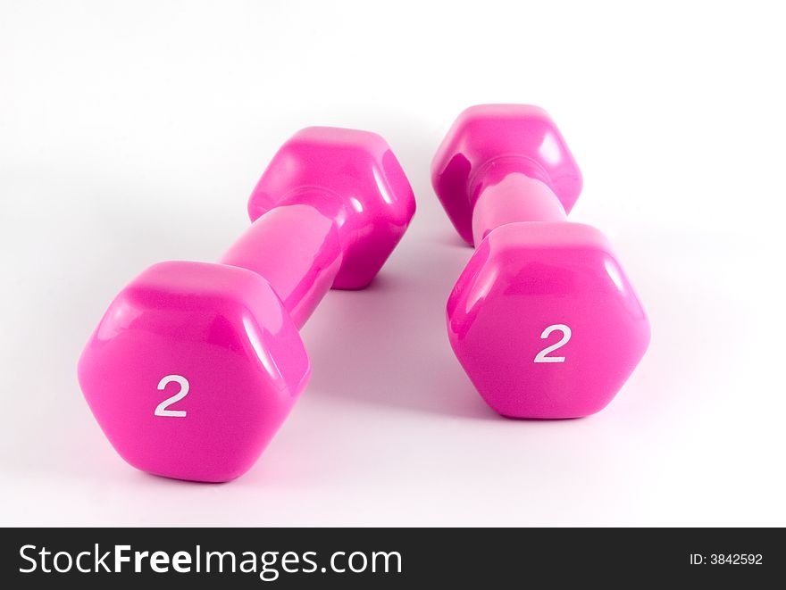Two pink dumbbells on the white background