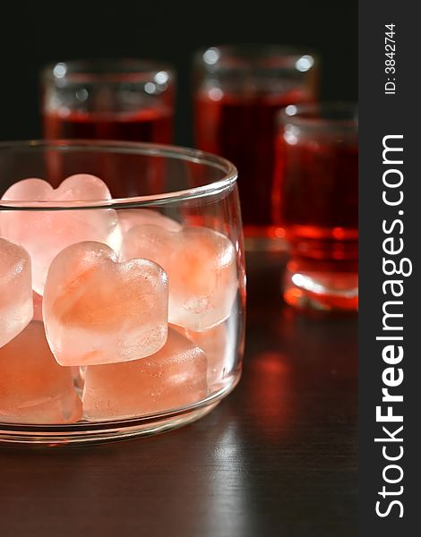 A bowl of pink heart shaped ice cubes and cocktails