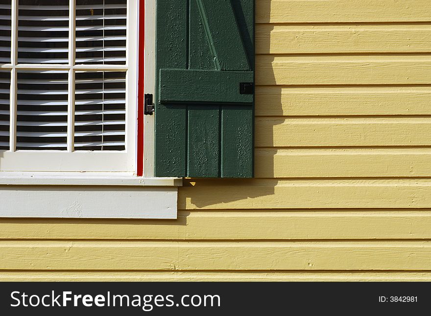 Image of a pretty gold house with a green shutter. Image of a pretty gold house with a green shutter