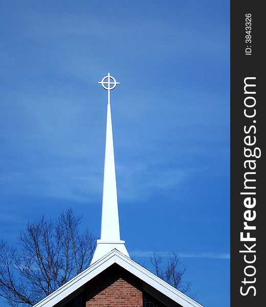 Church steeple topped with a cross and circle.