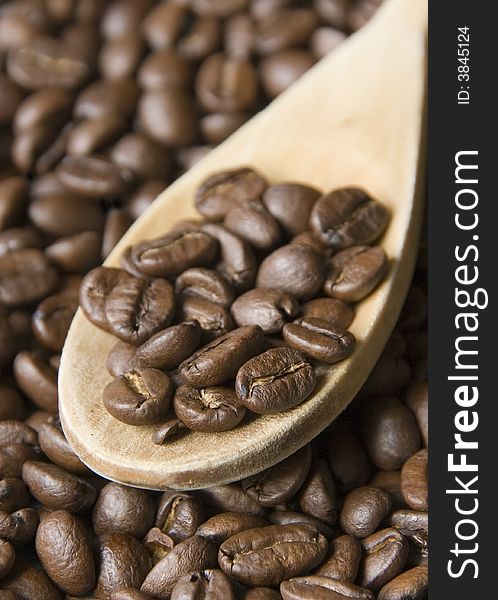 A wooden spoon on some real coffee grains. Shallow dpth of field, focus on the grains on the spoon. Close up shot. My COFFEE collection Â». A wooden spoon on some real coffee grains. Shallow dpth of field, focus on the grains on the spoon. Close up shot. My COFFEE collection Â»