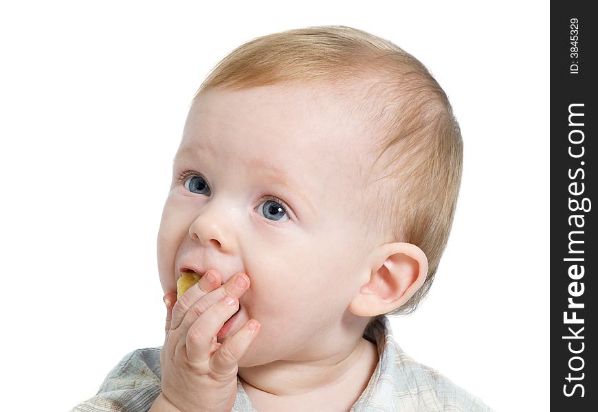 12-month old blue eyed toddler eating a piece of banana. 12-month old blue eyed toddler eating a piece of banana