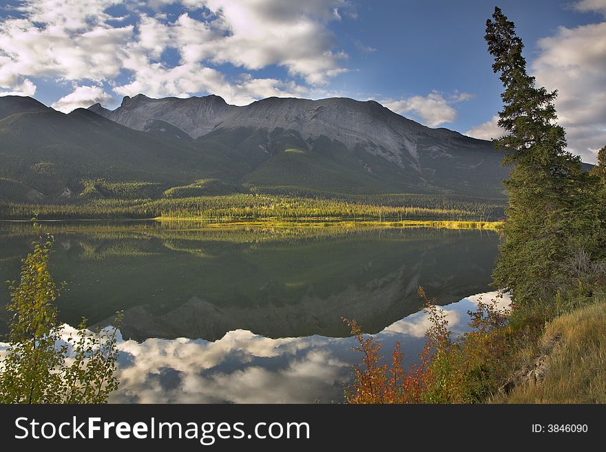 Mountain lake the reflecting sky and mountains in the cold morning. Mountain lake the reflecting sky and mountains in the cold morning