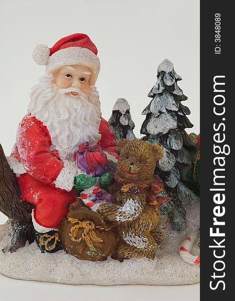 Photo of toy Santa Claus and bear holding a rucksack with toys and gifts. Photo of toy Santa Claus and bear holding a rucksack with toys and gifts