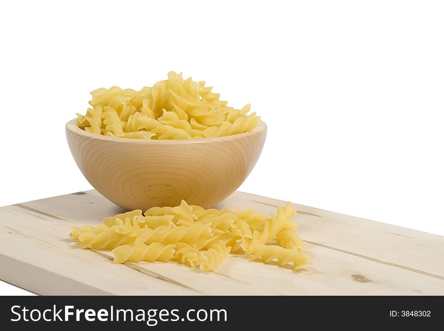 Spiral pasta in wooden dish and on wooden board, isolated on white. Spiral pasta in wooden dish and on wooden board, isolated on white