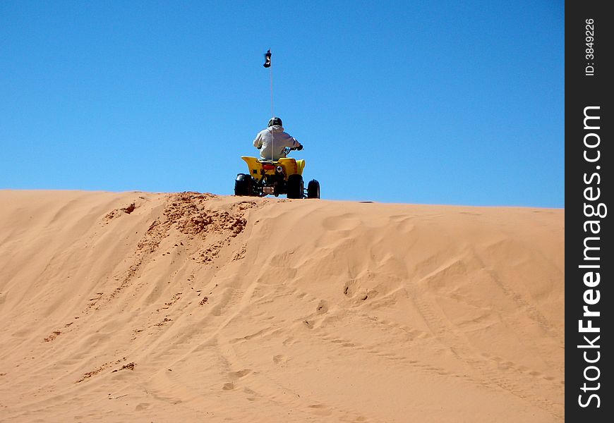 Rider on recreational vehicle on the dunes. Rider on recreational vehicle on the dunes
