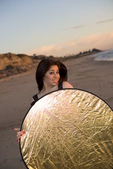 Model Holding A Reflector At The Beach At Sunset Stock Photo