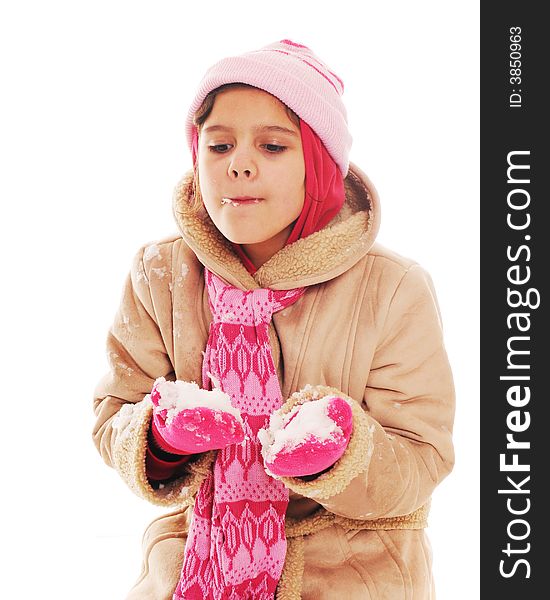 Bundled elementary girl eating snow off her mittens.  Isolated on white.