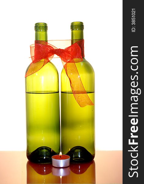 Two wine bottles, bow, candle