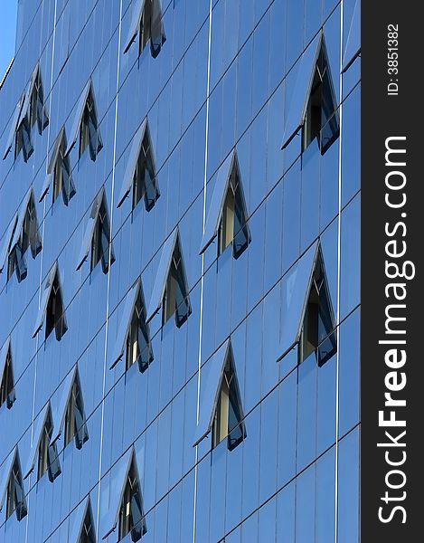 Modern skyscraper window reflections, blue sky mirrored