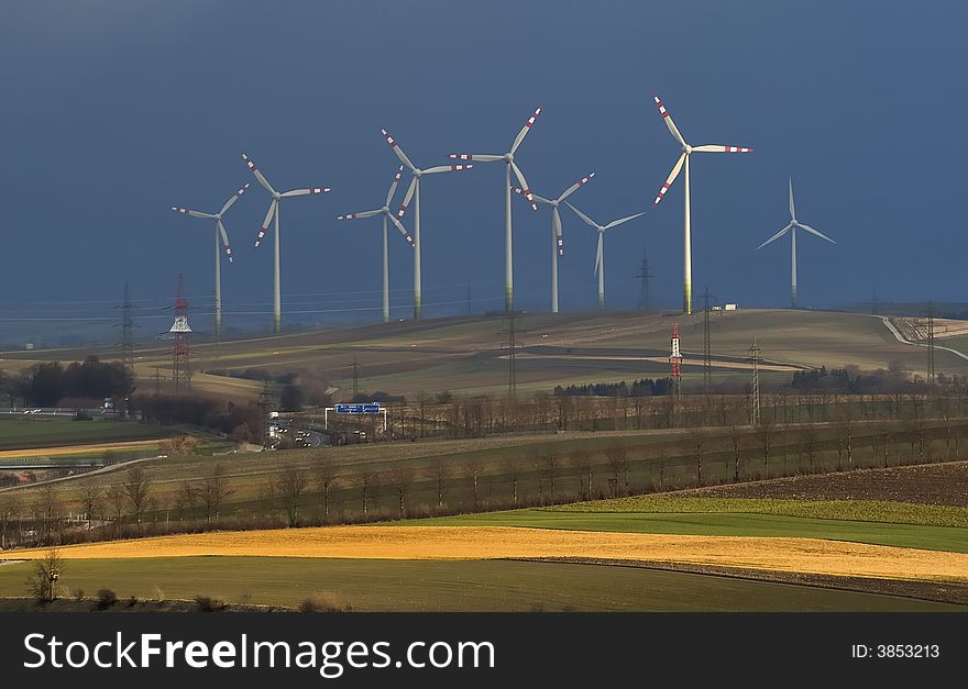 Windmills and motorway at the horizon with cloudy sky. Windmills and motorway at the horizon with cloudy sky