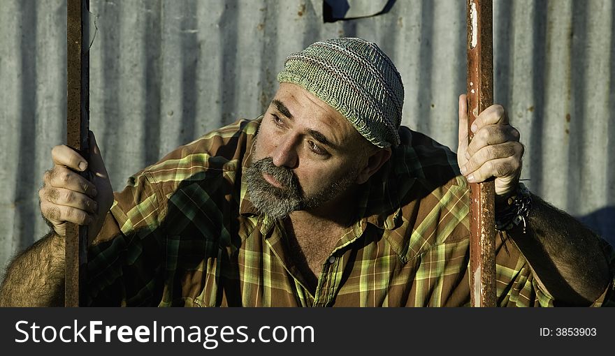 Scruffy man in a plaid shirt looking off camera. Scruffy man in a plaid shirt looking off camera.