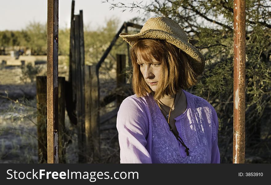 Woman wearing a cowboy hat in a rural setting. Woman wearing a cowboy hat in a rural setting.